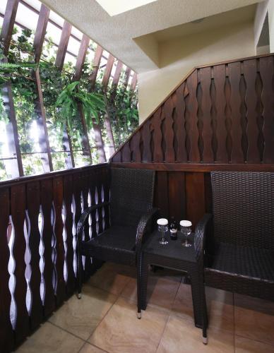 two chairs and a table on a balcony with windows at Hotel Carmen in Predeal
