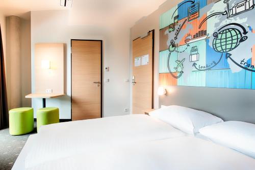 a bedroom with a white bed and a painting on the wall at B&B Hotel Stuttgart-Neckarhafen in Stuttgart