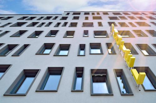 a tall white building with yellow accents at B&B Hotel Wien-Hbf in Vienna