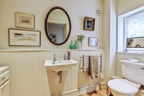 a bathroom with a sink and a toilet and a mirror at The Old Rectory Lodge in Dorchester