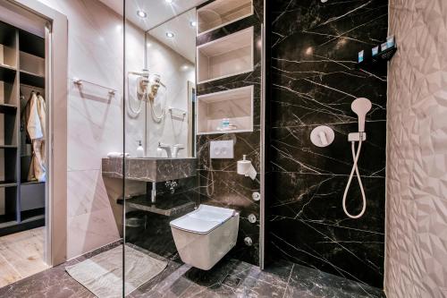 a bathroom with a toilet and a glass shower at Dedaj Resort - Villa Almaro in Zadar