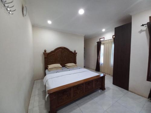 una camera con letto in legno di Collection O 92634 Villa Ds a Sumedang