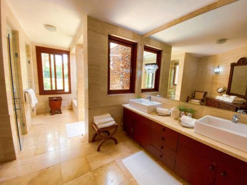 a large bathroom with two sinks and a large mirror at Mangos 13 Beautiful 5 bedroom villa with maid golf cart in La Romana