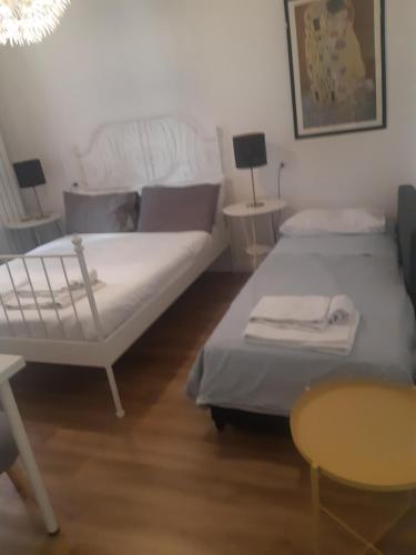 uma sala de estar com duas camas e uma mesa em Casa Deva em Florença