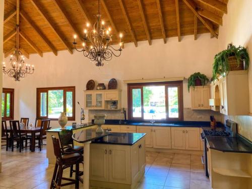 a large kitchen with a chandelier and a table at Mangos 13 Beautiful 5 bedroom villa with maid golf cart in La Romana