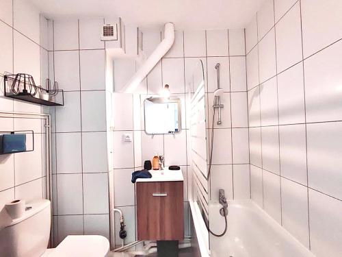 a bathroom with a sink and a tub and a toilet at Cosy F2 à proximité de PARIS in Savigny-sur-Orge