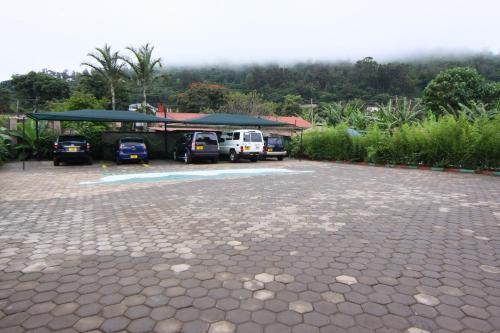 a parking lot with cars parked under a roof at Green Mountain Hotel in Arusha