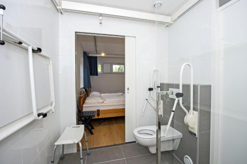 a bathroom with a toilet and a bed in a room at Vakantiepark Hellendoorn in Hellendoorn