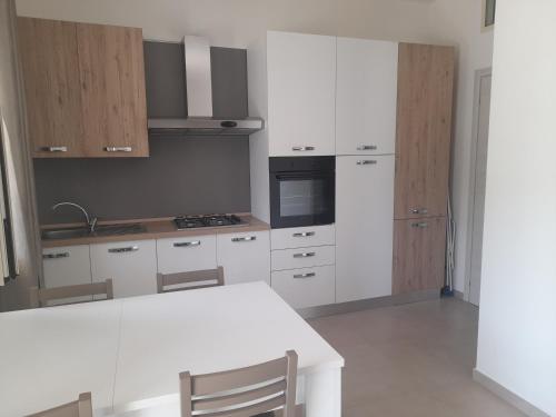 a kitchen with white cabinets and a white table at La Casa al Mare in Peschici