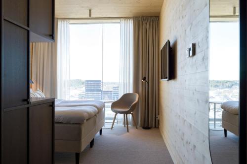 um quarto de hotel com uma cama e uma janela em The Wood Hotel by Elite, Spa & Resort em Skellefteå