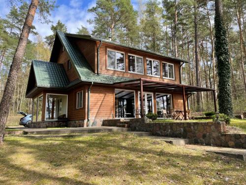 una casa con techo verde en el bosque en Villa Green Alchemy, en Molėtai