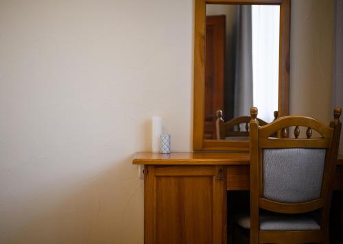 a bathroom with a desk with a mirror and a chair at Bogolvar Retreat Resort in Antonovka