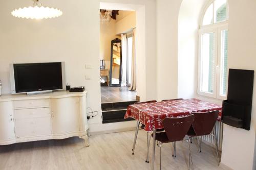 a dining room with a table and a tv and a table and chairs at Villa Gioia in Acqui Terme