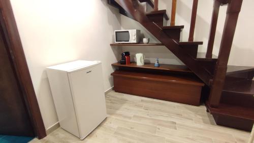 einen kleinen Kühlschrank in einem Zimmer mit einer Treppe in der Unterkunft Il Tartarughino in Nettuno