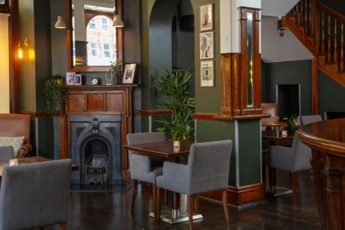 a restaurant with a fireplace and tables and chairs at The Crown London, WorldHotels Distinctive in London