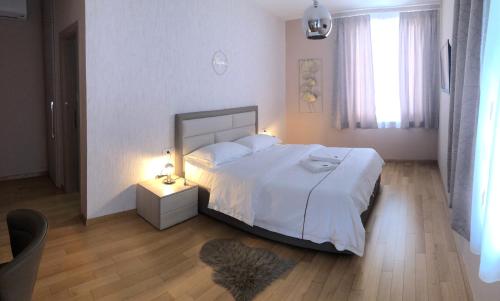 ein Schlafzimmer mit einem großen Bett mit weißer Bettwäsche und einem Fenster in der Unterkunft Zoilo Rooms self check-in in Zadar