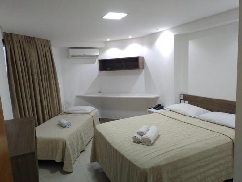 a hotel room with two beds with towels on them at Nomar VI - Gold Flat in João Pessoa