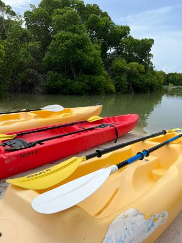 a group of three kayaks sitting on the water at Wish Guesthouse in Huraa