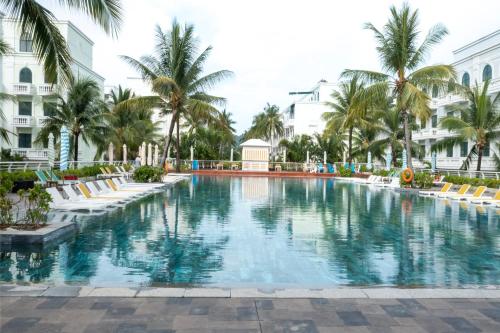 duży basen z palmami i budynkami w obiekcie Golden Dragon Hotel w Duong Dong