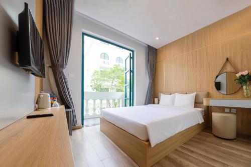 sypialnia z łóżkiem, telewizorem i oknem w obiekcie Golden Dragon Hotel w Duong Dong