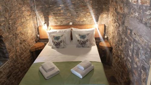 uma cama num quarto com duas almofadas em Αυθεντικό πετρινο στην Ναύπακτο em Lepanto
