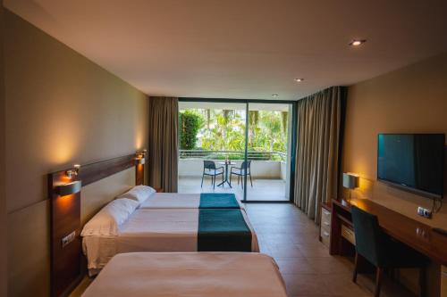 een hotelkamer met 2 bedden en een flatscreen-tv bij Hotel Deloix 4* Sup in Benidorm