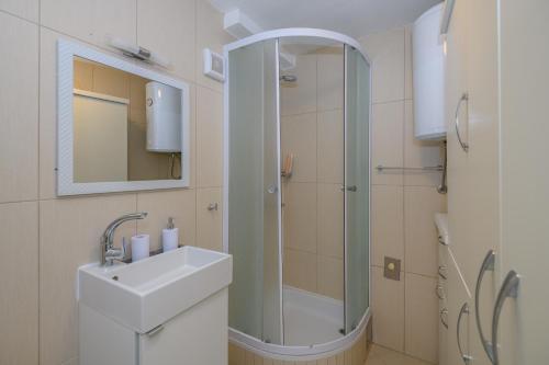 a white bathroom with a sink and a shower at Studio Esperanza Dubrovnik in Dubrovnik