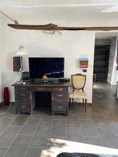 a desk with a television and a chair in a room at Villa Gioia in Acqui Terme