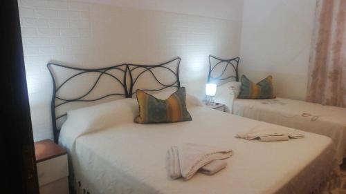 1 dormitorio con 2 camas con cabecero y toalla en Casa mirela apartment, en Cassibile
