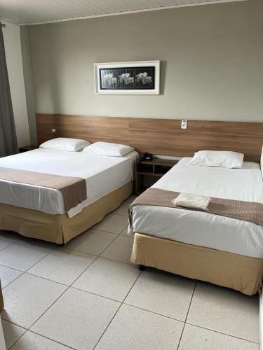 two beds in a hotel room with two beds sidx sidx sidx at Larison Economy by Easy Hotéis in Porto Velho