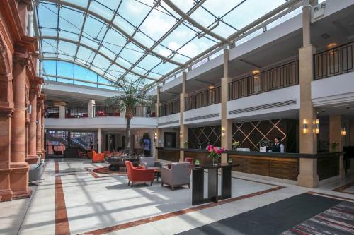 a large lobby with a glass ceiling and furniture at The Crown London, WorldHotels Distinctive in London