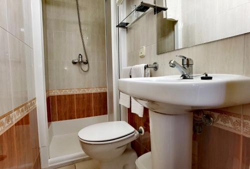 a bathroom with a sink and a toilet and a shower at HOSTAL RIGAU in Sant Feliu de Guíxols