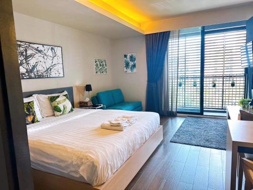sypialnia z dużym łóżkiem i niebieskim krzesłem w obiekcie Stylish 1 Bedroom, Nice pool,Bts Asok, Sukhumvit w mieście Bangkok