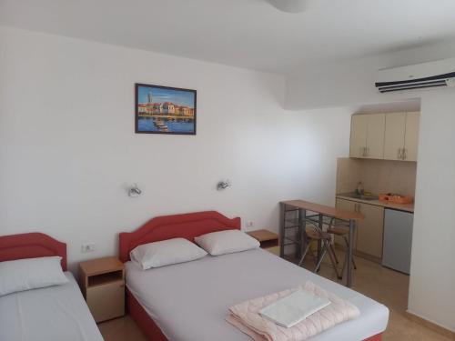 a bedroom with two beds and a small kitchen at Apartments Percobic in Sutomore