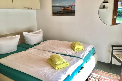 a room with two beds with yellow towels on them at Ferienhaus Min Hüsing in Loddin