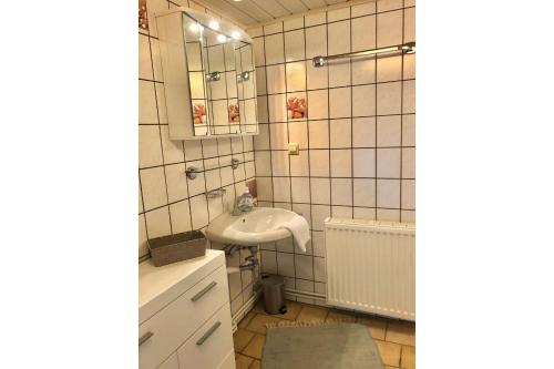 a bathroom with a sink and a mirror at Ferienhaus Min Hüsing in Loddin
