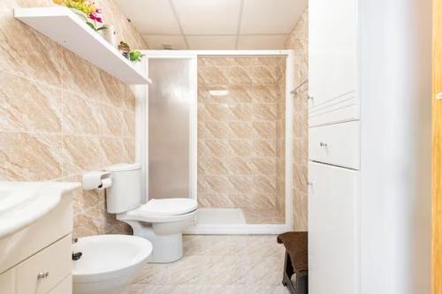 薩洛的住宿－Salou Garden，白色的浴室设有卫生间和淋浴。