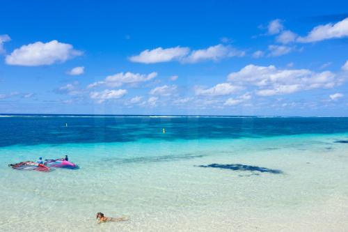 a person laying in the water at a beach at Beach Penthouse BELMARE in Belle Mare