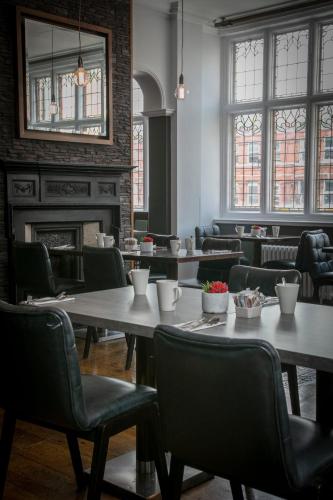 a restaurant with tables and chairs and a fireplace at The Crown London, WorldHotels Distinctive in London