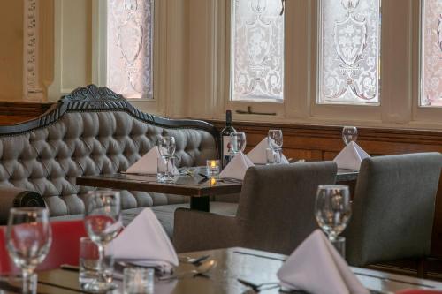 a restaurant with tables and chairs with wine glasses at The Crown London, WorldHotels Distinctive in London