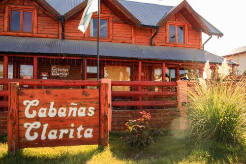 a wooden house with a fence in front of it at Cabañas Clarita in Dina Huapi