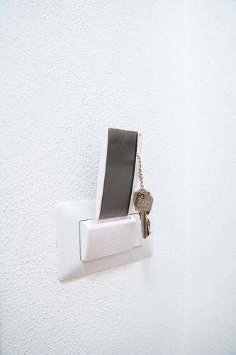 a white light with a key hanging on a wall at Kalipe House in Bosa