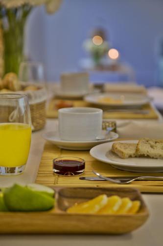 une table avec des assiettes de nourriture et un verre de jus d'orange dans l'établissement Lisbon Five Stars Apartments Combro 77, à Lisbonne