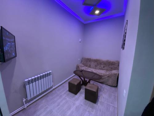 a room with a couch and a table and a tv at KosMos Guest House in Gyumri