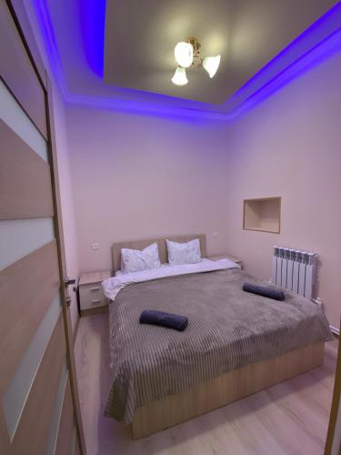una camera con letto e soffitto viola di KosMos Guest House a Gyumri
