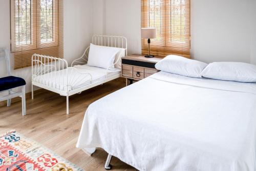 ein Schlafzimmer mit einem weißen Bett und einem Stuhl in der Unterkunft Private Villa With Garden Near Beaches in Marmaris in Marmaris