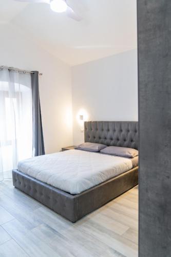 a large bed in a bedroom with a large window at Kalipe House in Bosa