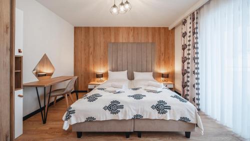 a bedroom with a bed and a desk and a desk at Apartamenty Sun & Snow SKI Apartments in Białka Tatrzańska