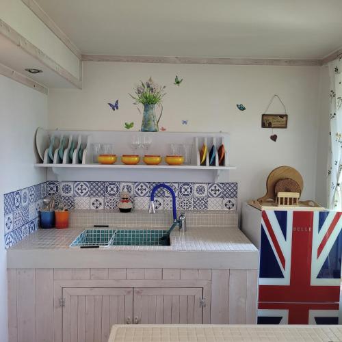 a kitchen with blue and white tiles on the wall at Soulmate Pension in Namhae