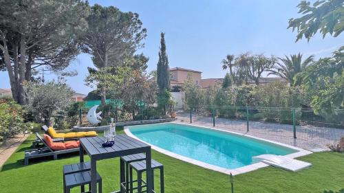 une piscine dans une cour avec une table et des chaises dans l'établissement Mazets du Soleil, à Sainte-Maxime
